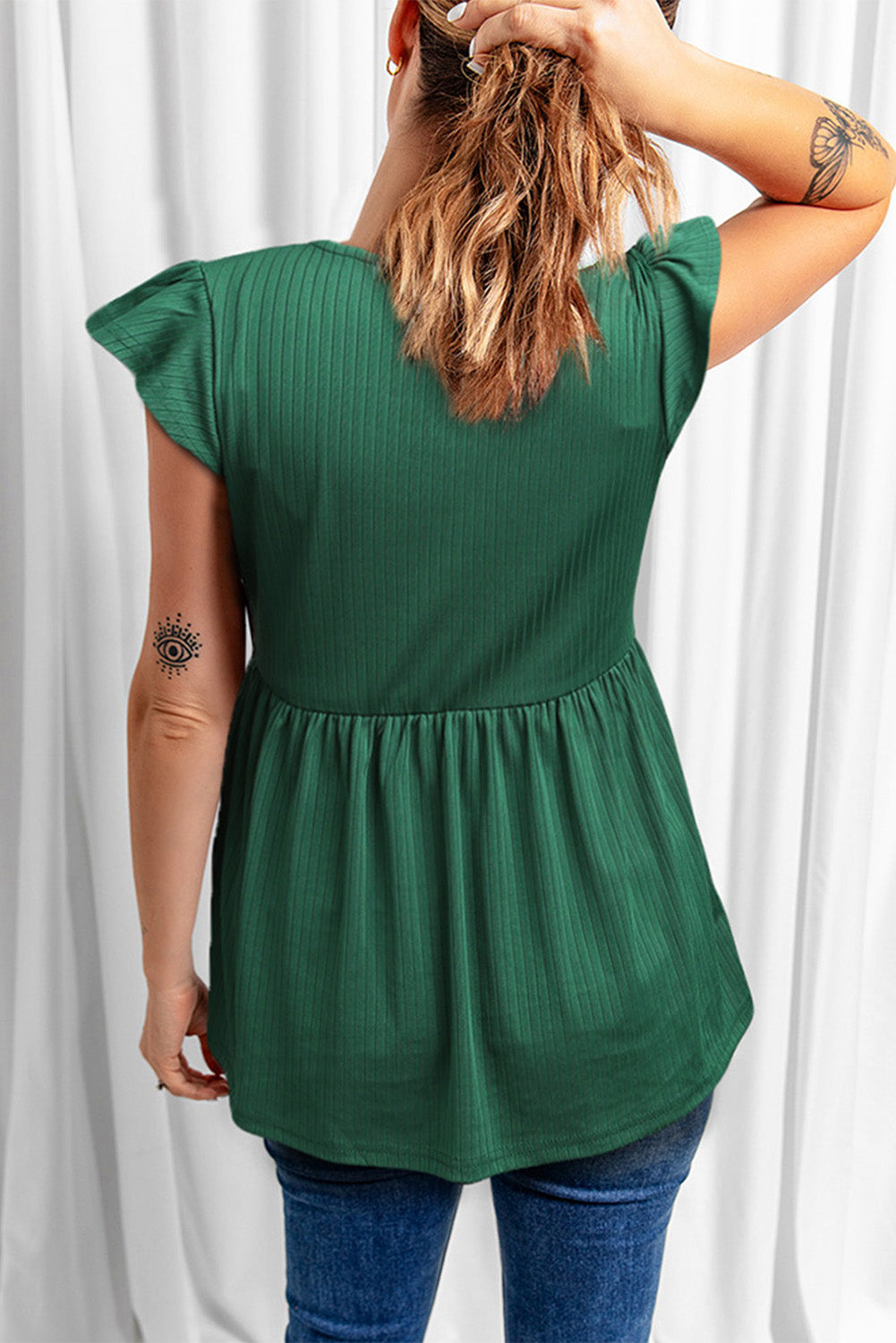 A stylish green V neck babydoll top featuring flutter sleeves and a flowy silhouette, perfect for casual outings.