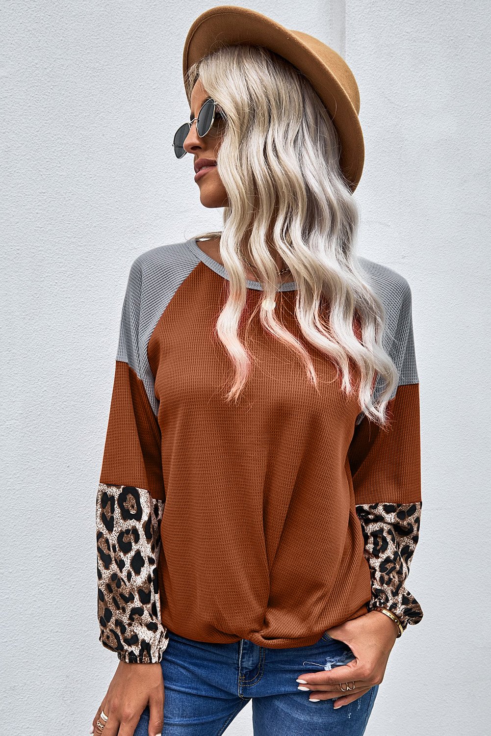 Knit Orange Blouse with leopard print cuffs and relaxed fit, showcasing a stylish design.