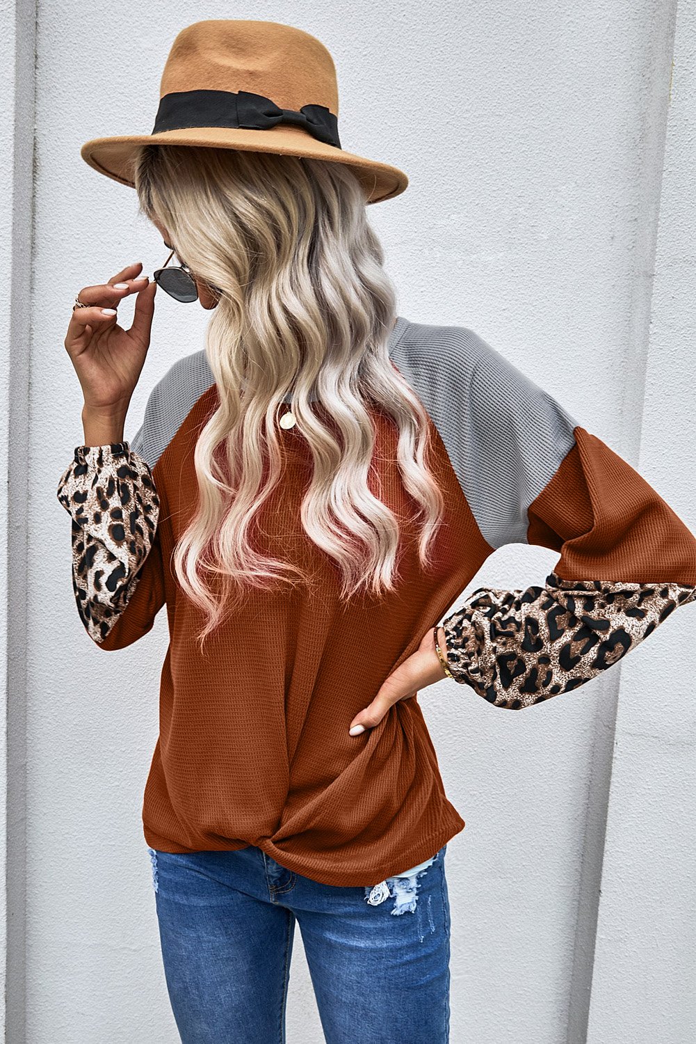 Knit Orange Blouse with leopard print cuffs and relaxed fit, showcasing a stylish design.