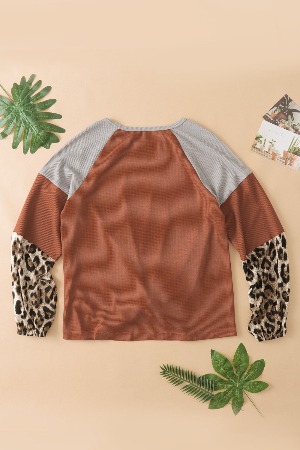 Knit Orange Blouse with leopard print cuffs and relaxed fit, showcasing a stylish design.