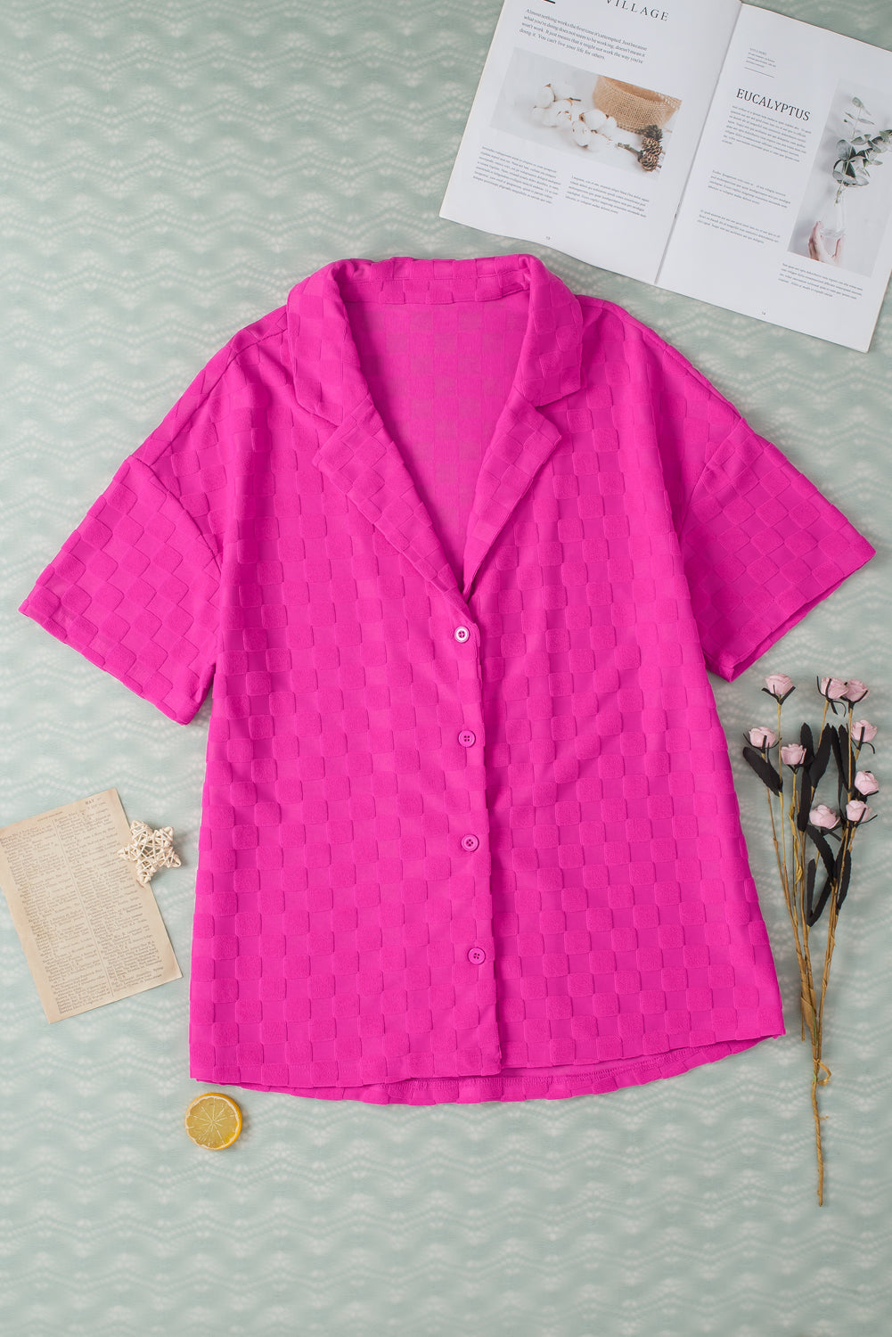 Bright pink lapel textured short sleeve shirt displayed on a hanger, showcasing its elegant design and chic style.