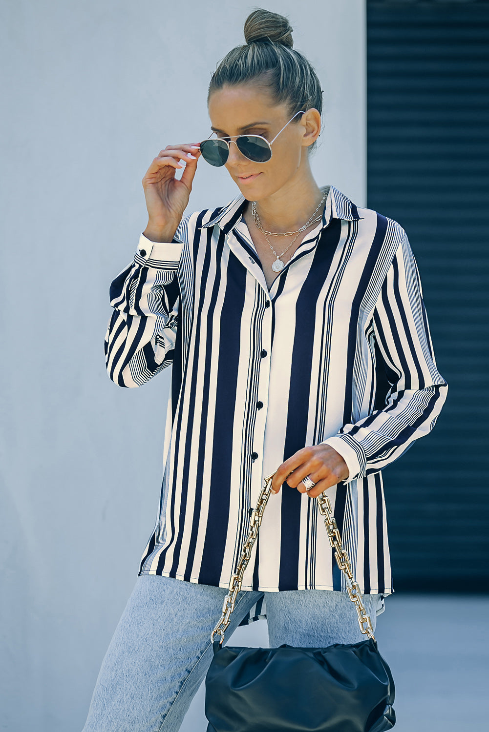 A stylish navy striped modern women's shirt featuring long sleeves and a tunic length, perfect for work or casual outings.