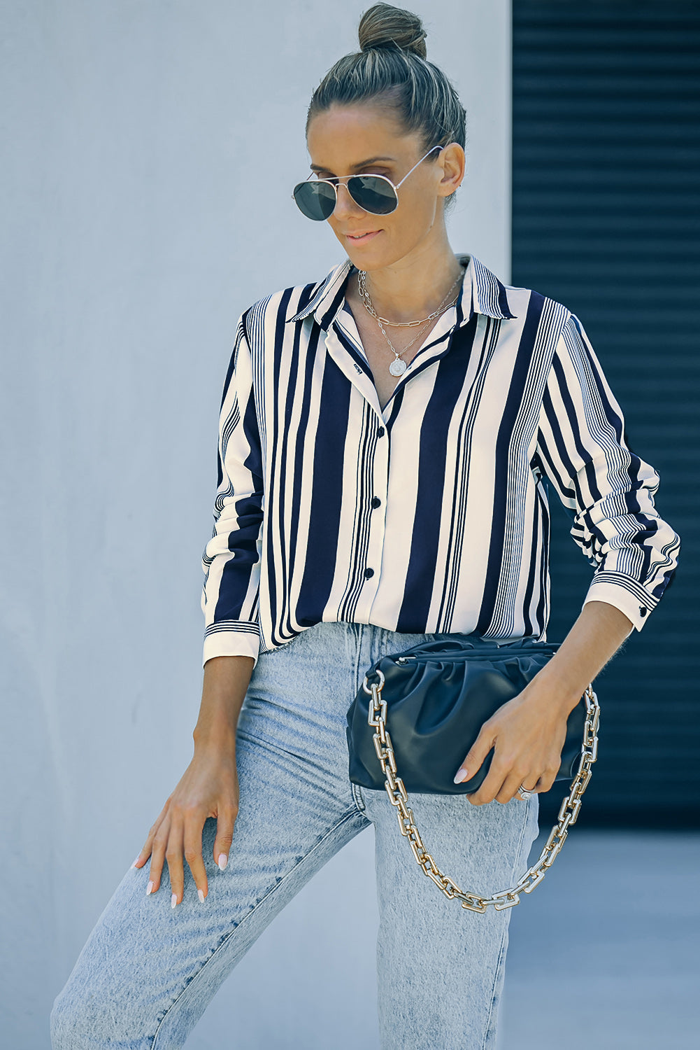 A stylish navy striped modern women's shirt featuring long sleeves and a tunic length, perfect for work or casual outings.