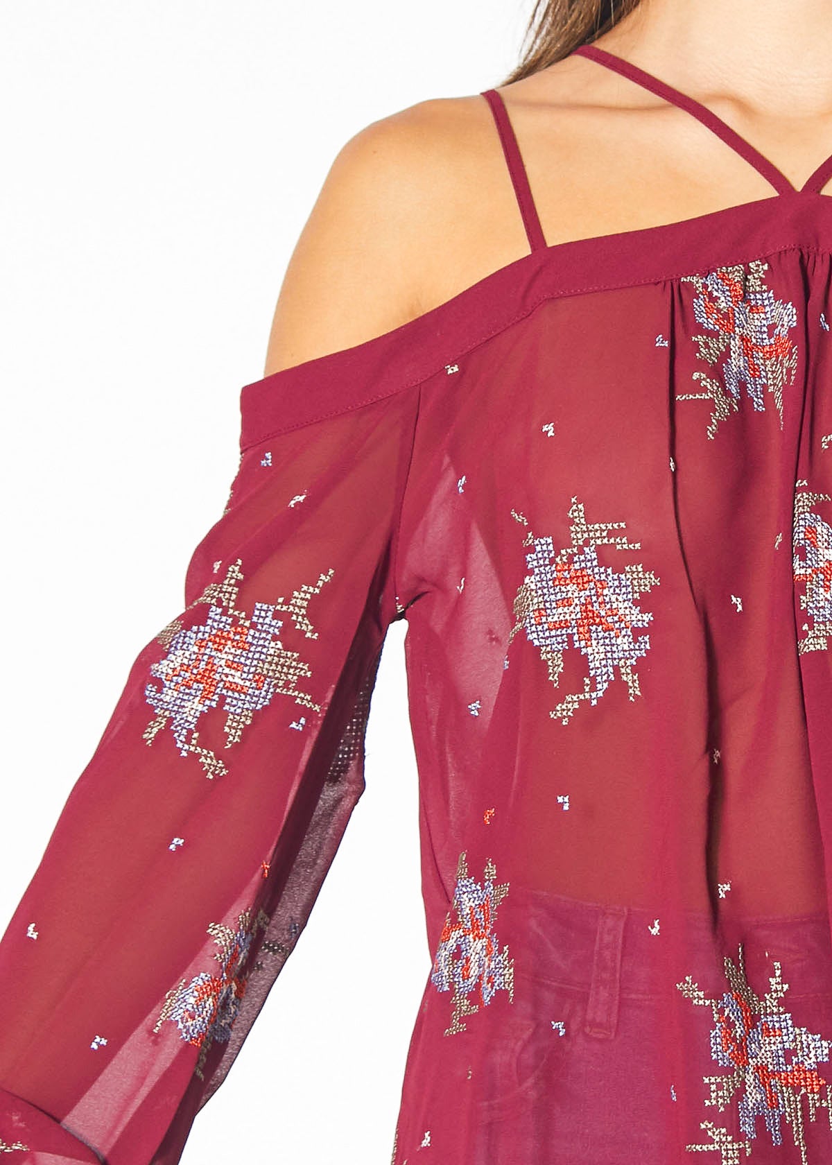 A stylish off-shoulder blouse in burgundy featuring intricate embroidery prints, perfect for dressing up denim outfits.