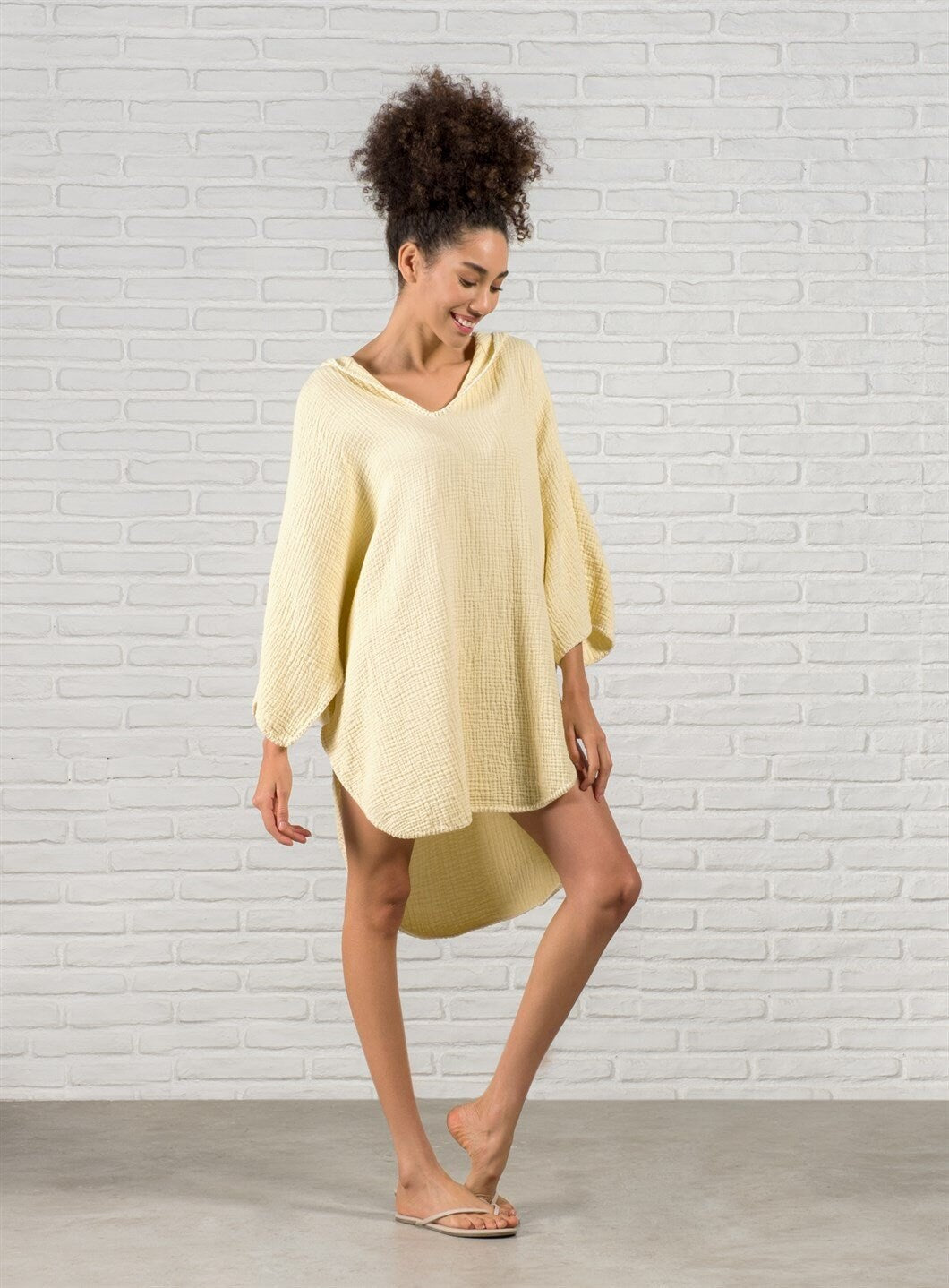 A stylish Organic Cotton Surf Poncho in a vibrant color, showcasing its handmade quality and pocket details, perfect for beach and pool use.