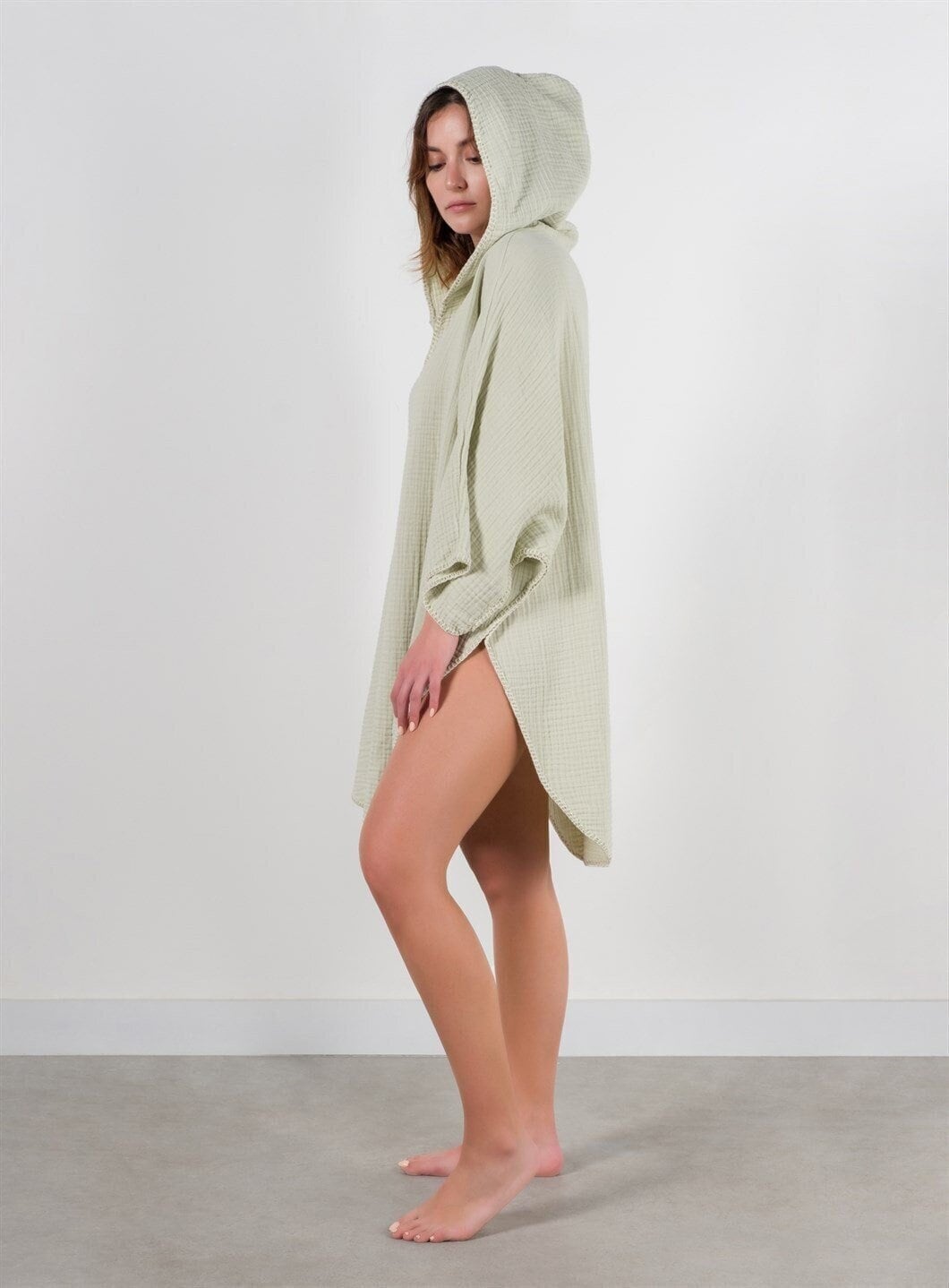 A stylish Organic Cotton Surf Poncho in a vibrant color, showcasing its handmade quality and pocket details, perfect for beach and pool use.