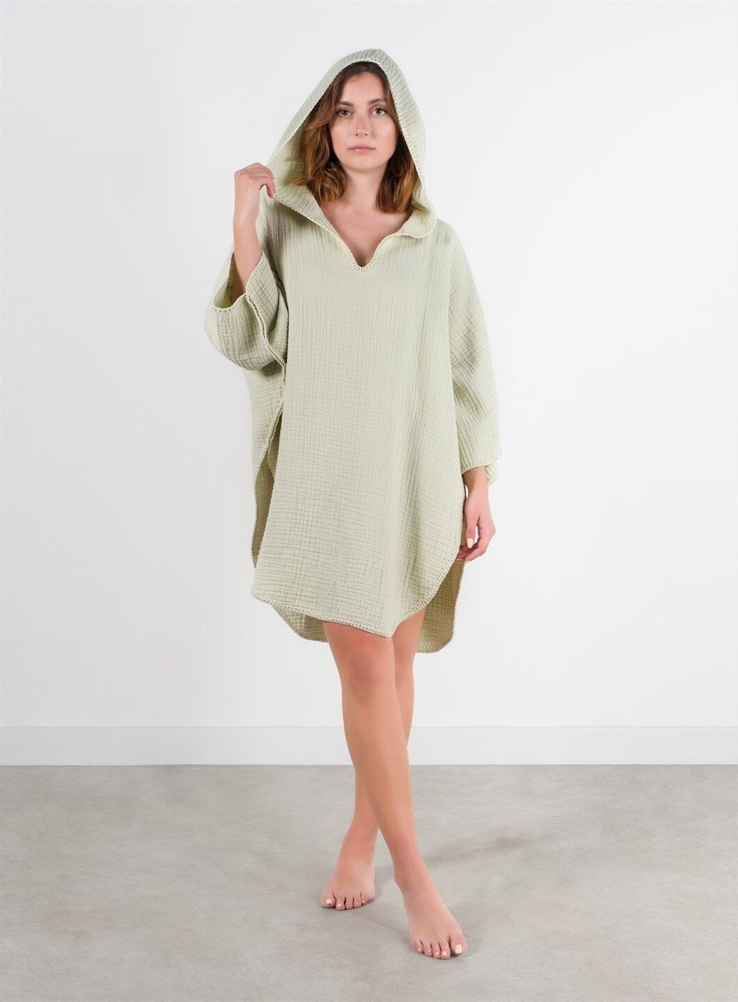 A stylish Organic Cotton Surf Poncho in a vibrant color, showcasing its handmade quality and pocket details, perfect for beach and pool use.