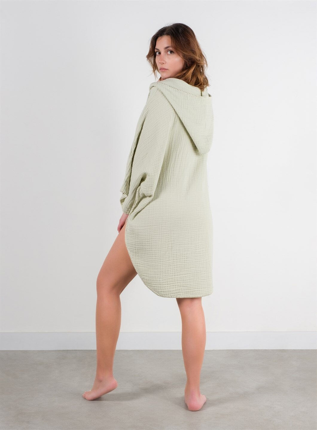 A stylish Organic Cotton Surf Poncho in a vibrant color, showcasing its handmade quality and pocket details, perfect for beach and pool use.