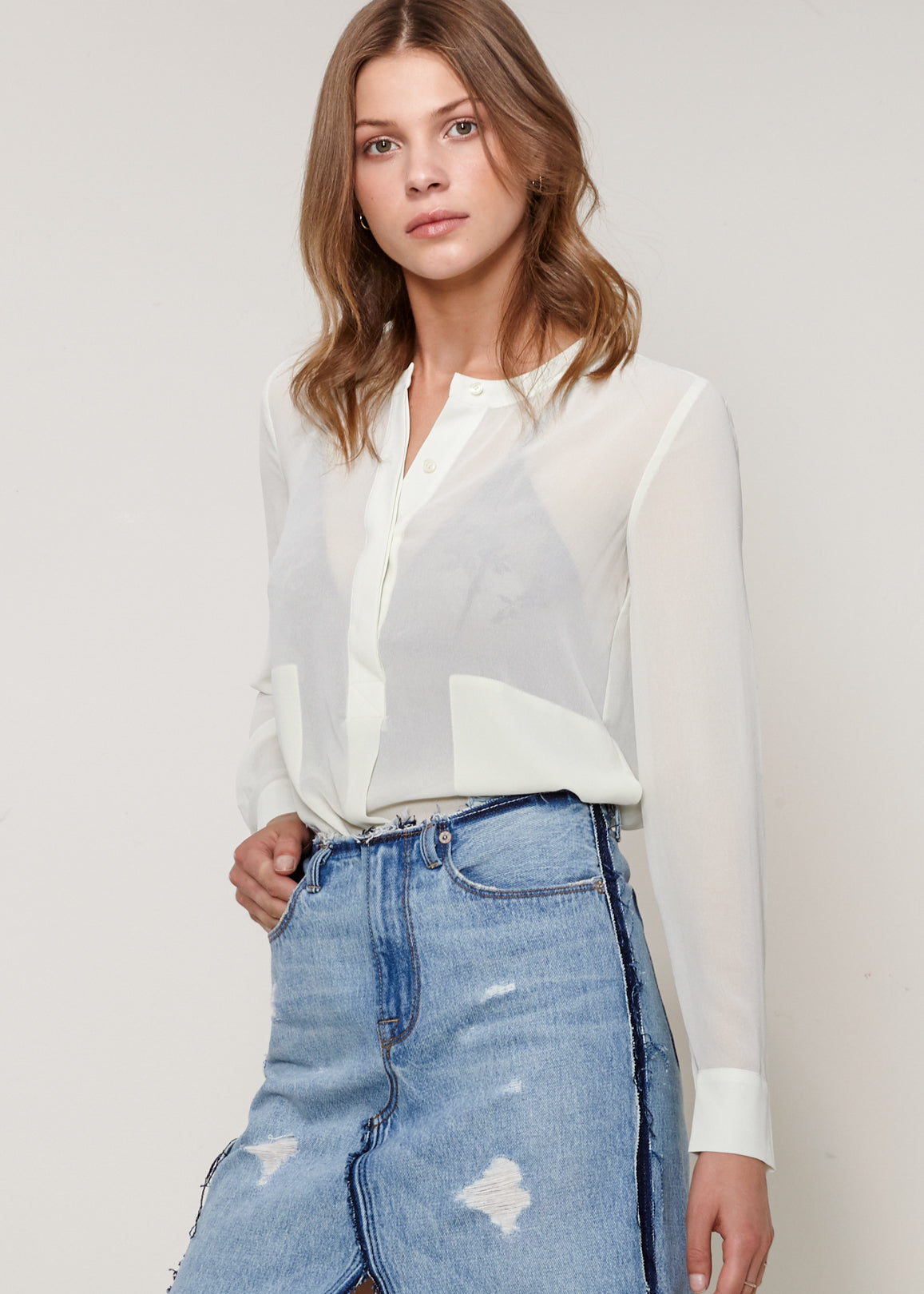 A stylish sheer button-up blouse with long sleeves, round neck, and two pockets, made from 100% polyester.