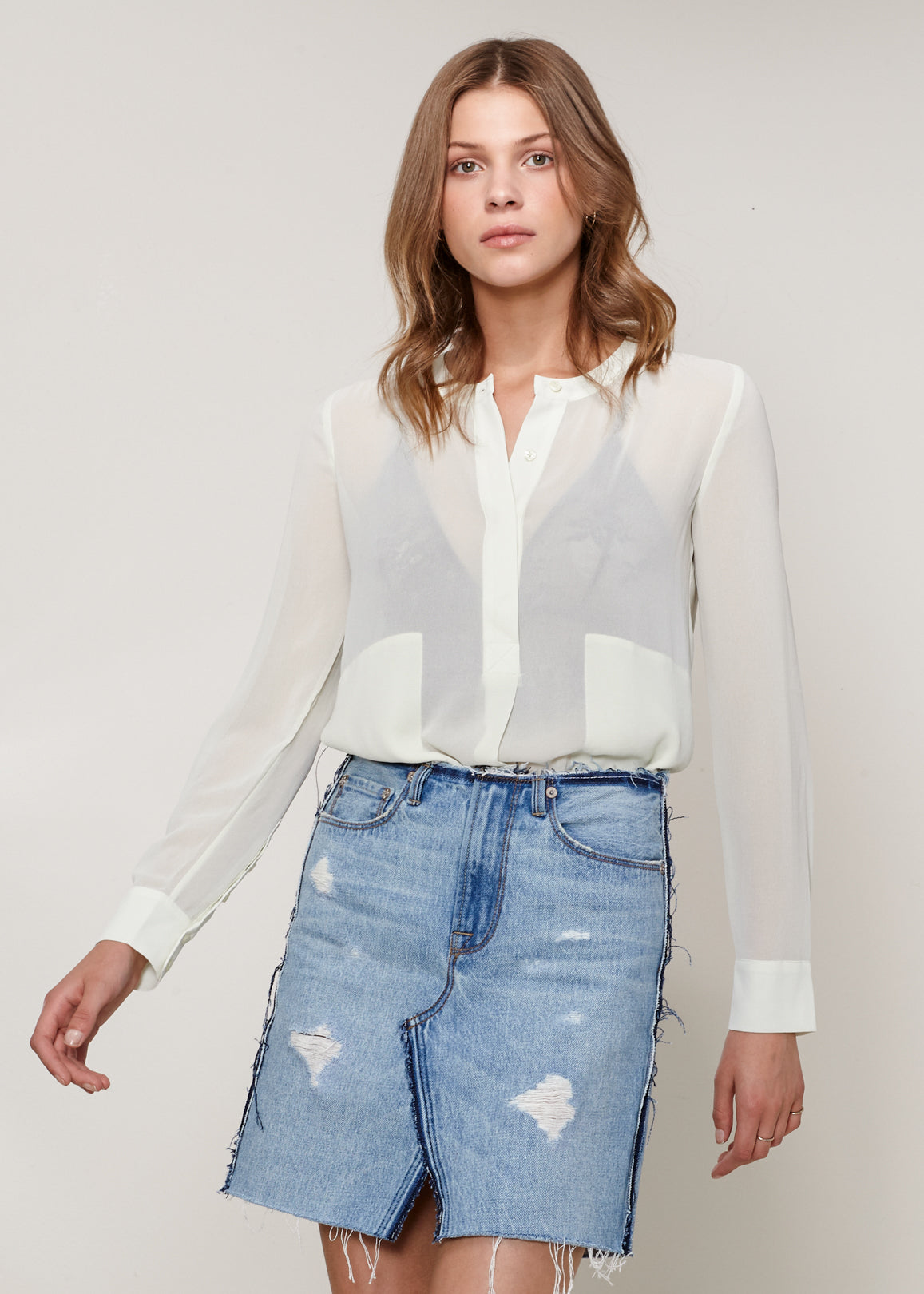 A stylish sheer button-up blouse with long sleeves, round neck, and two pockets, made from 100% polyester.