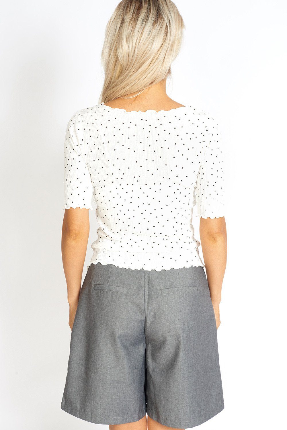 So Sweet Frill Polka Dots Top featuring a modest round neck, ruffled edges, and baseball style sleeves in a lightweight fabric.