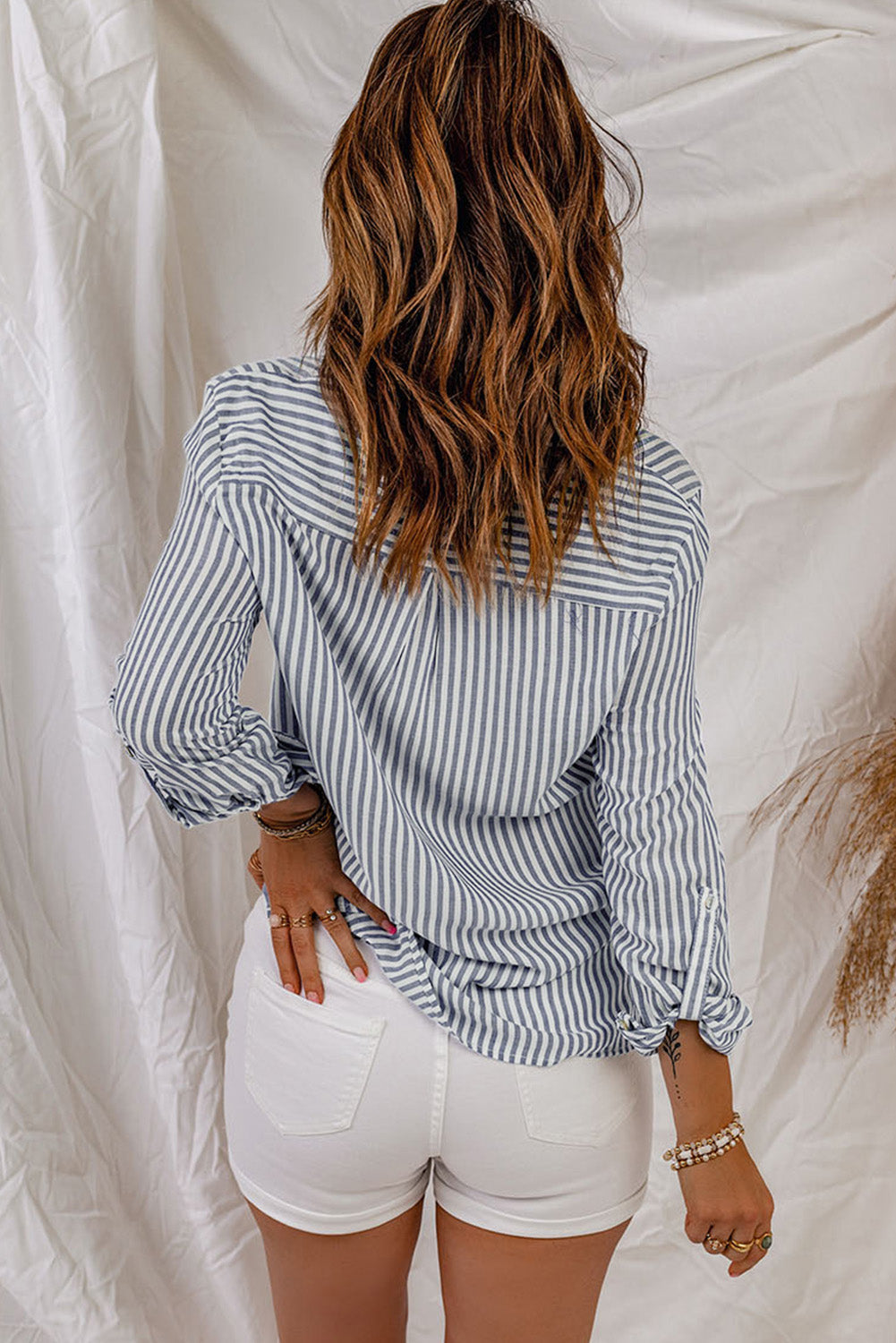 A stylish women's long sleeve shirt featuring a striped pattern, button-down front, and practical pockets, perfect for casual and formal occasions.