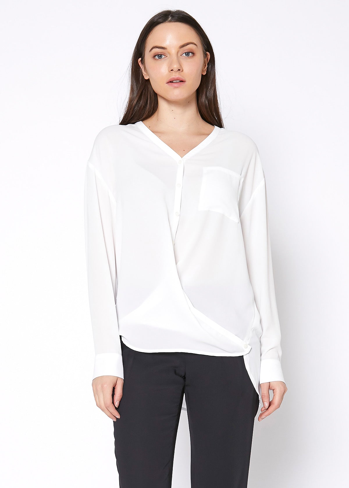 A stylish V-Neck Wrap Hem Blouse featuring a pleated front and hi-lo design, with long sleeves and single button cuffs, made from 100% polyester.