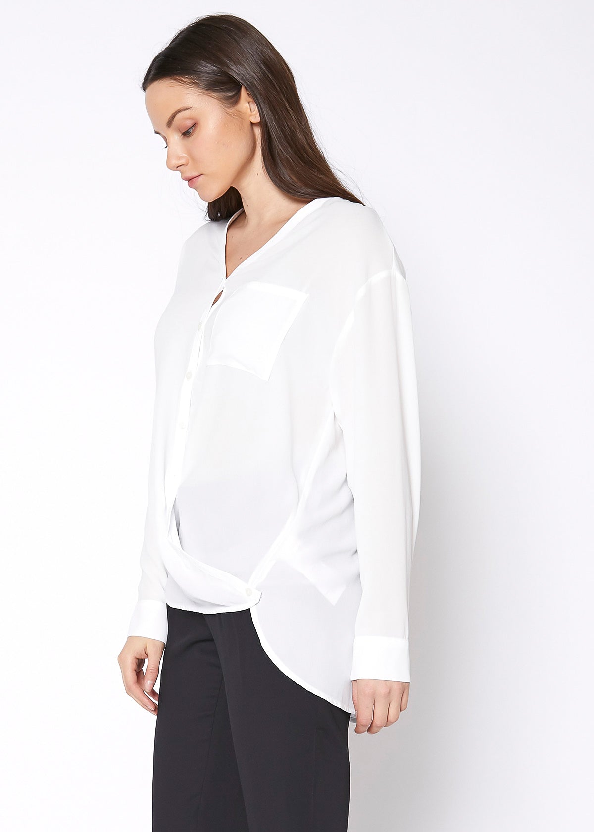 A stylish V-Neck Wrap Hem Blouse featuring a pleated front and hi-lo design, with long sleeves and single button cuffs, made from 100% polyester.