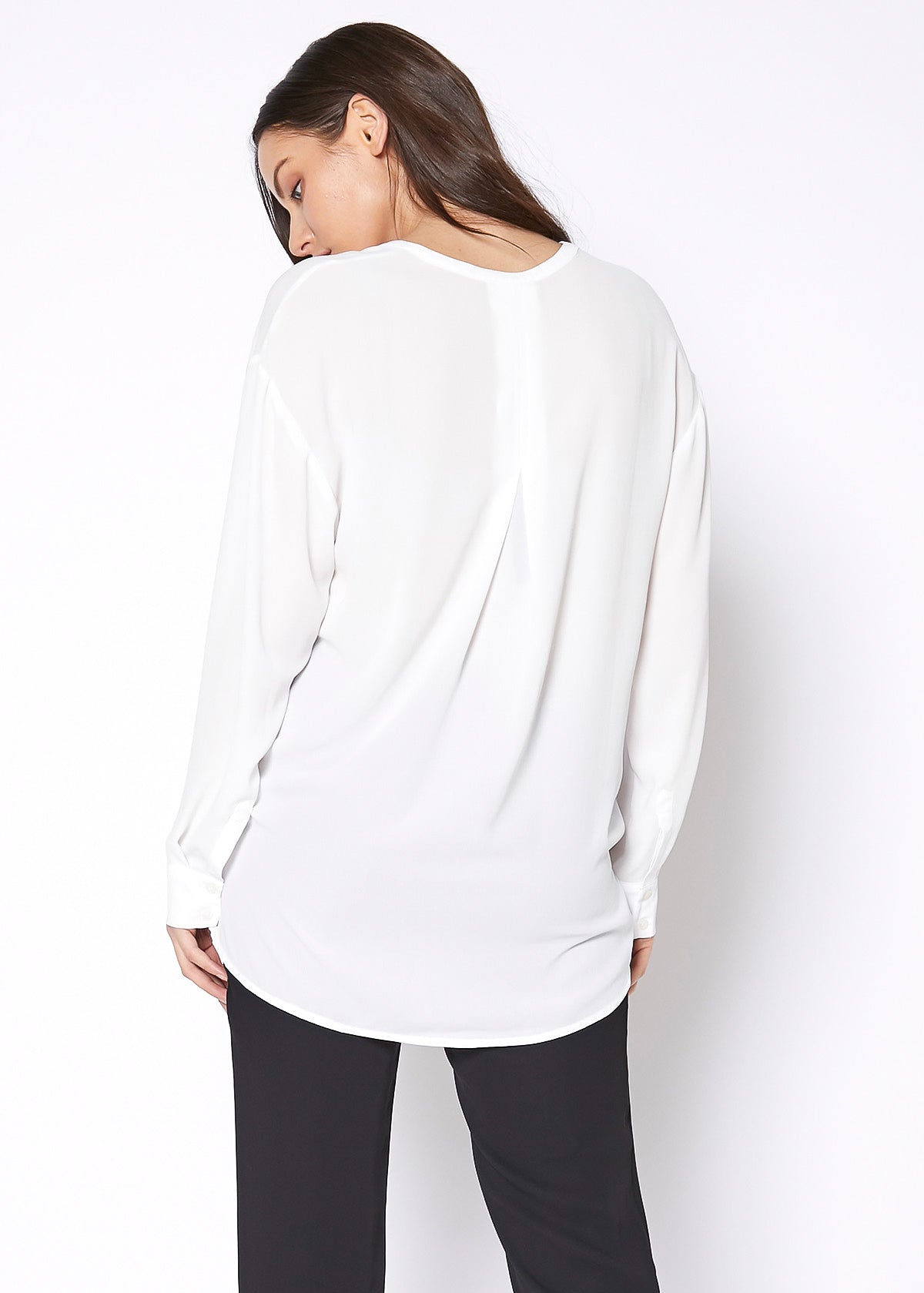 A stylish V-Neck Wrap Hem Blouse featuring a pleated front and hi-lo design, with long sleeves and single button cuffs, made from 100% polyester.