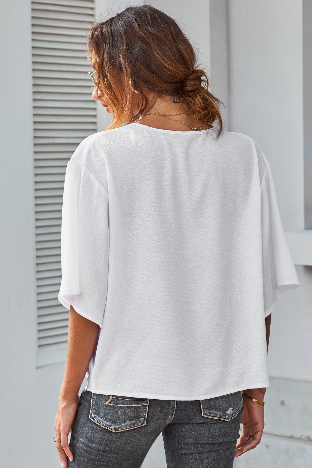 White draped short sleeve chic blouse with a loose front design, perfect for casual and semi-formal occasions.