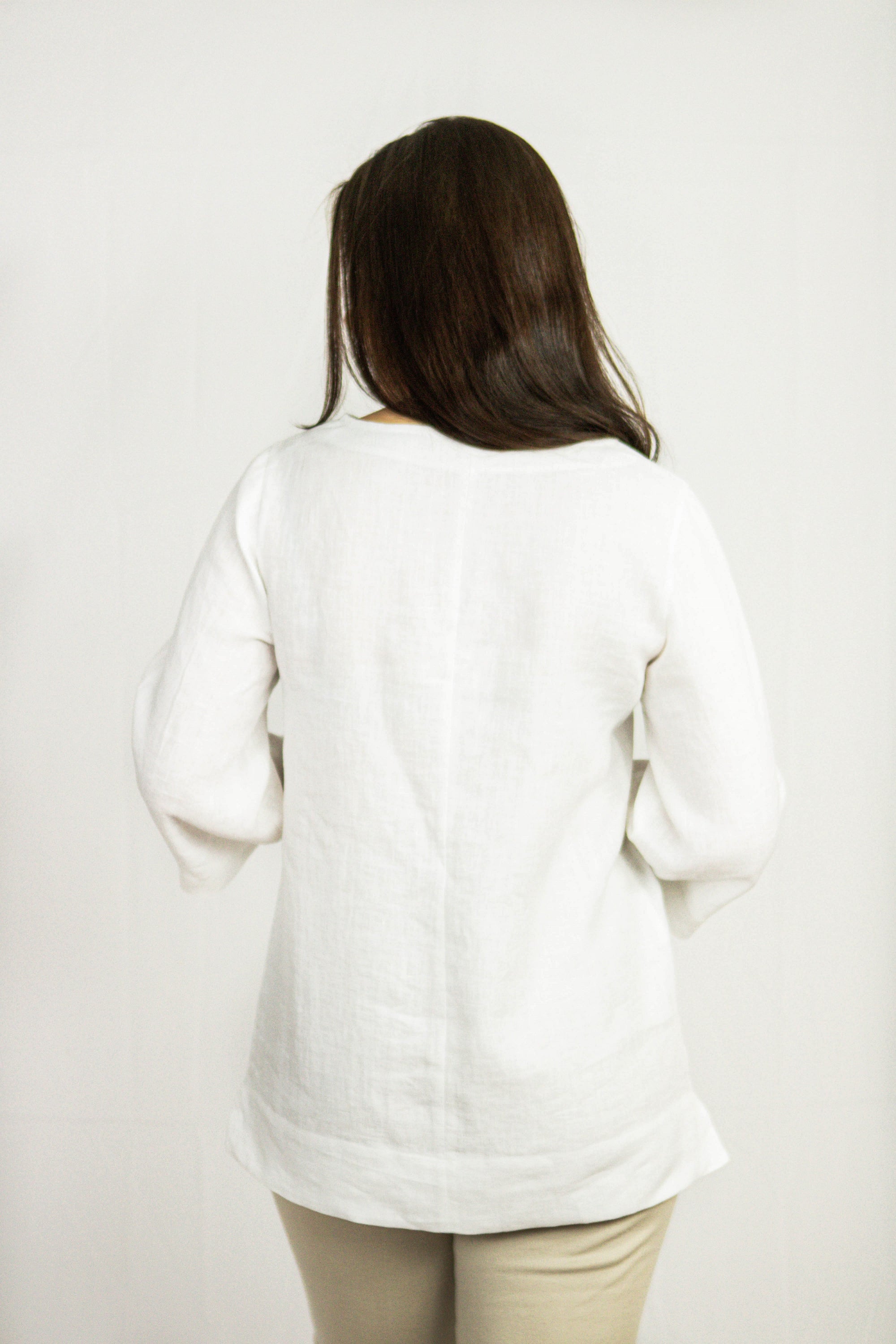 A stylish white linen oversize top displayed on a mannequin, showcasing its elegant design and breathable fabric.