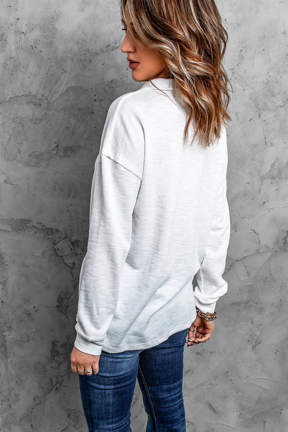 A stylish white long sleeve top with a turn-down neck and button closure, perfect for casual wear in spring and autumn.