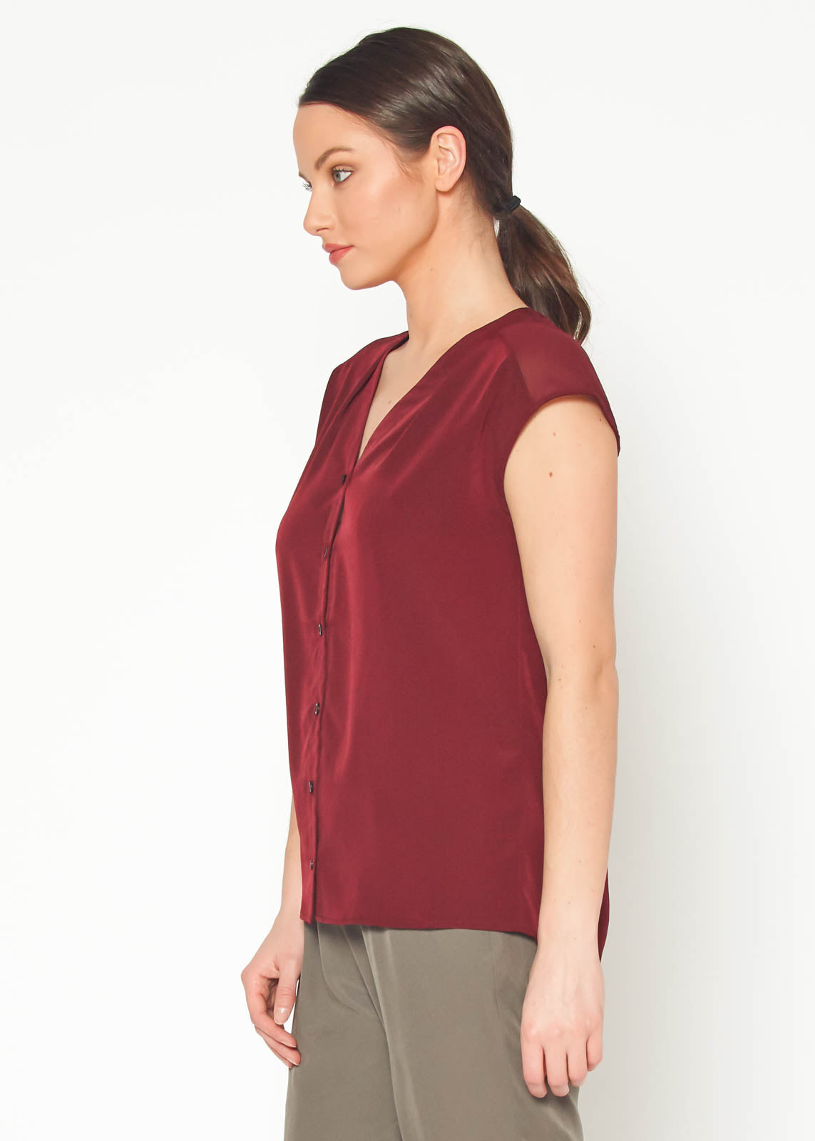 Women's burgundy sleeveless V neck button top displayed on a mannequin, showcasing its elegant design and fabric texture.