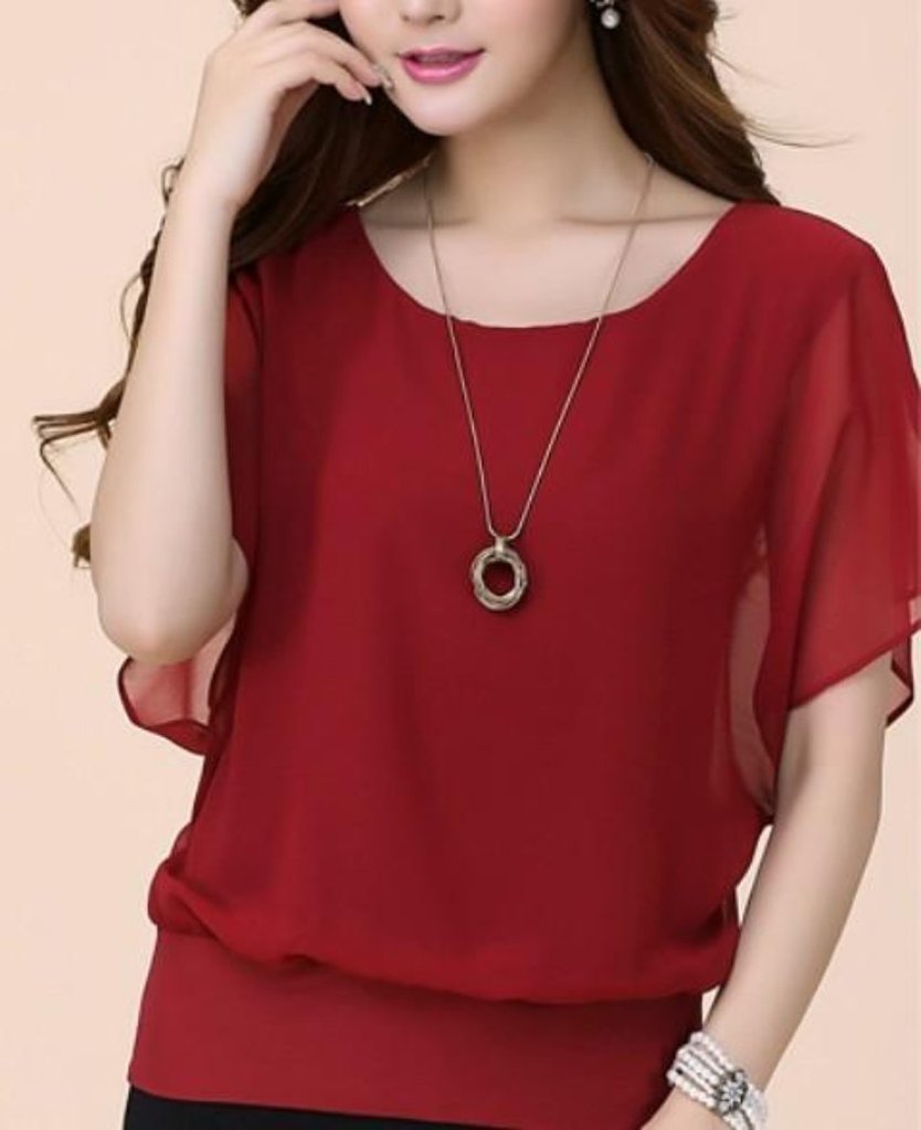 Woman wearing red blouse and necklace.