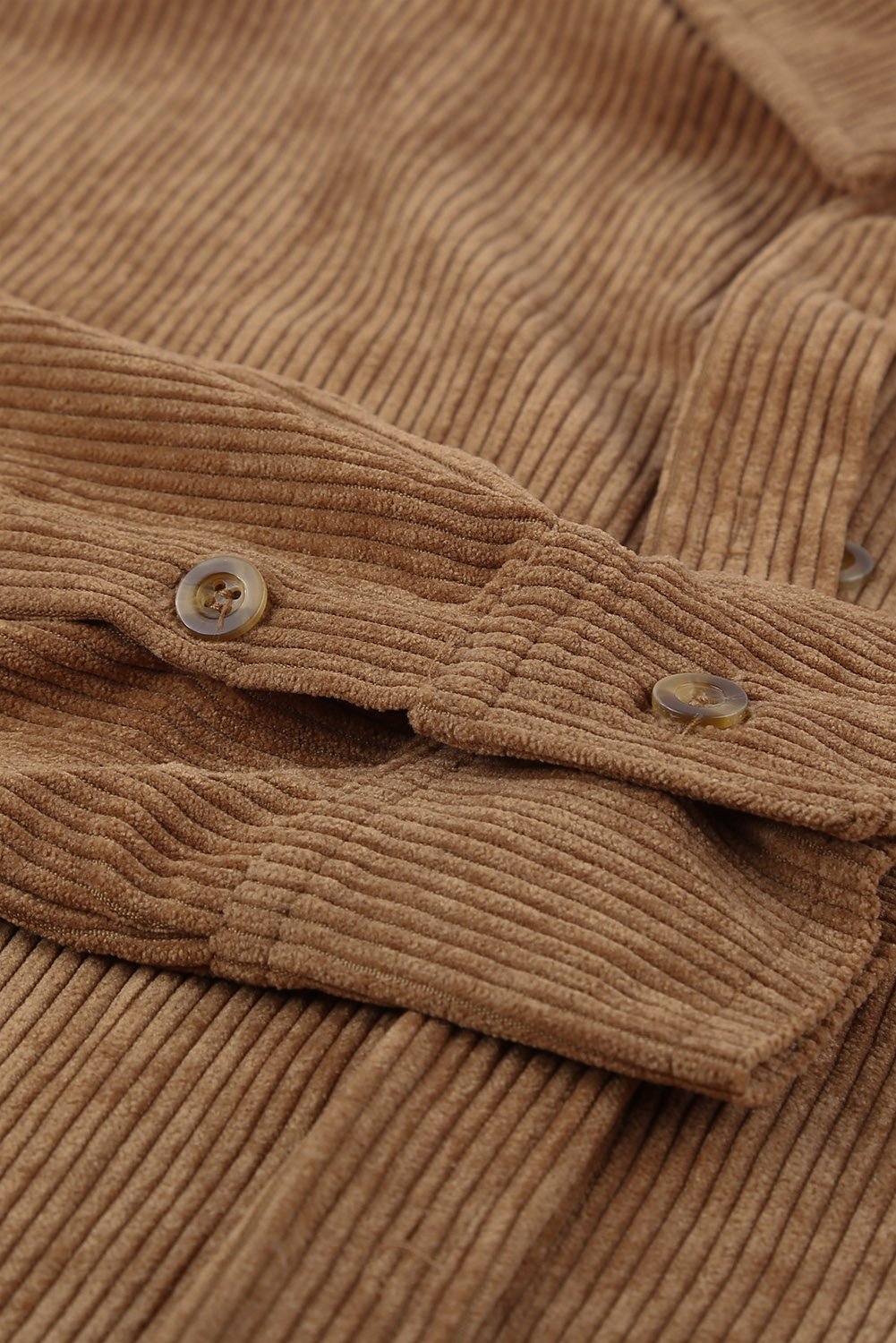 A stylish women's brown corduroy button pocket shirt with full sleeves and a turn-down collar, featuring button cuffs and two front pockets.