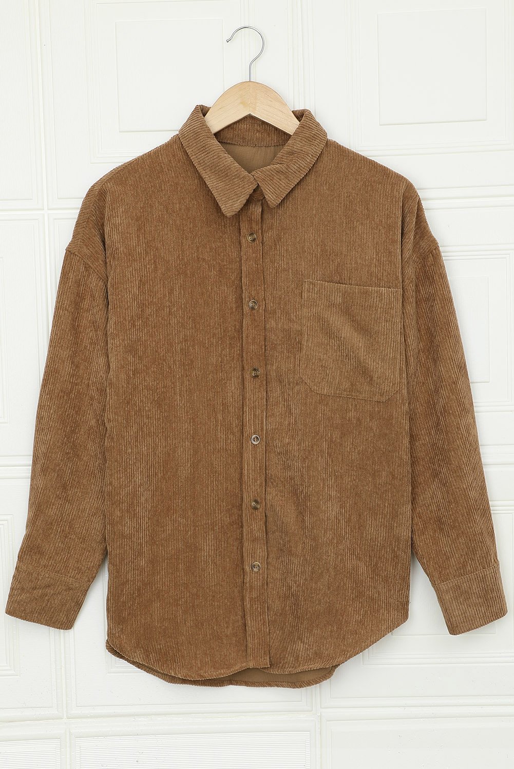 A stylish women's brown corduroy button pocket shirt with full sleeves and a turn-down collar, featuring button cuffs and two front pockets.