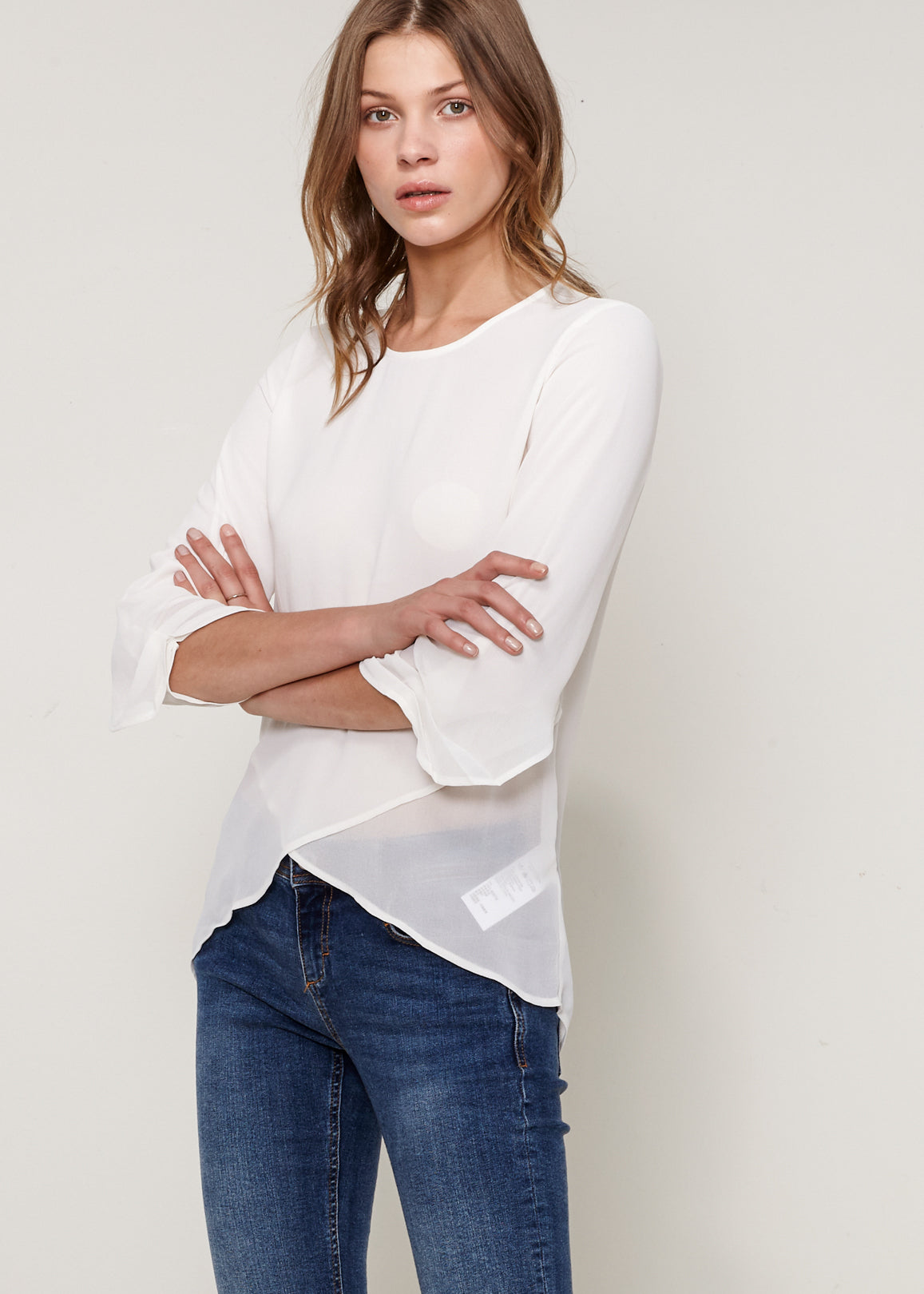 Women's Cross Hem Blouse featuring a surplice hem and gathered cuff details, made from lightweight polyester.