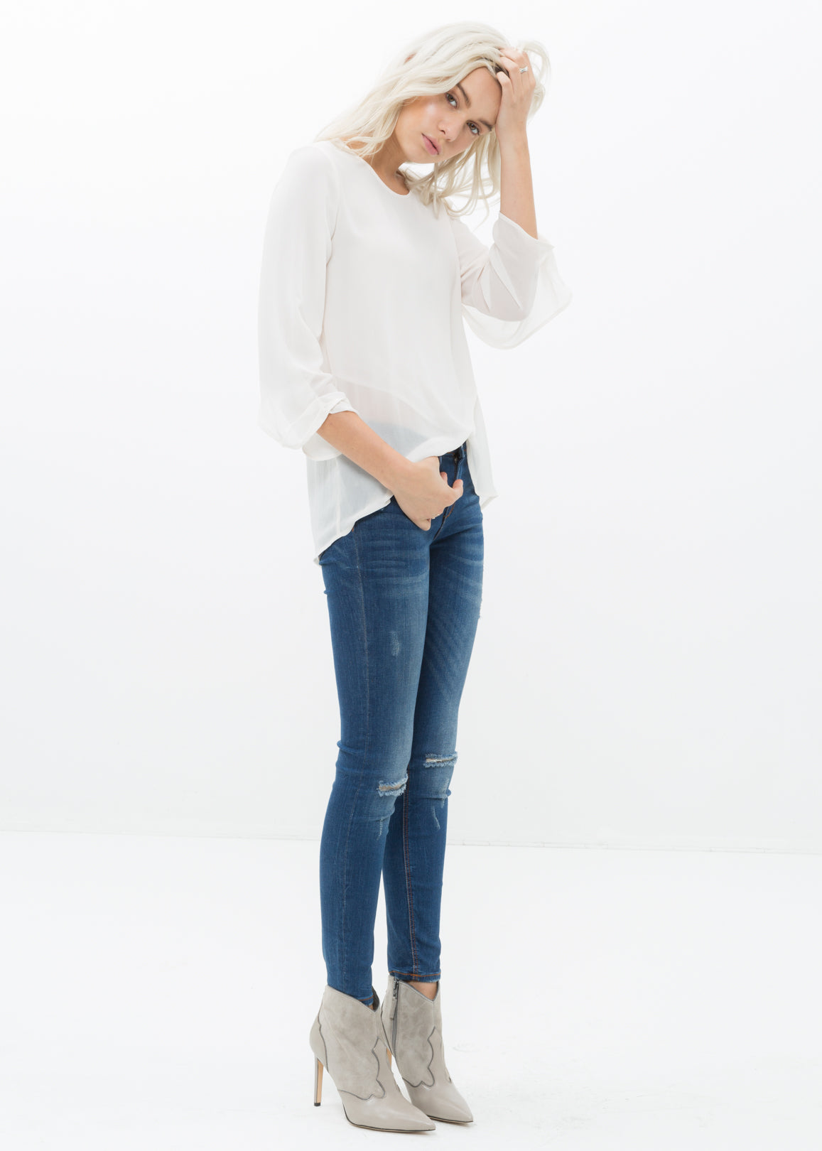 Women's Cross Hem Blouse featuring a surplice hem and gathered cuff details, made from lightweight polyester.