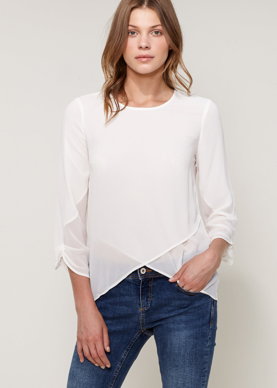 Women's Cross Hem Blouse featuring a surplice hem and gathered cuff details, made from lightweight polyester.