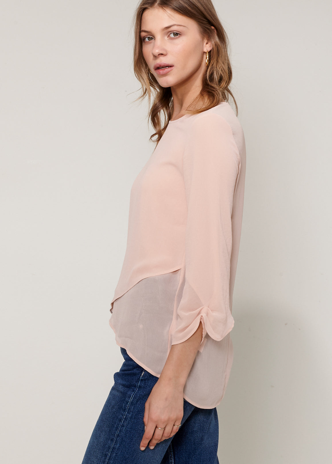 Women's Cross Hem Blouse featuring a surplice hem and gathered cuff details, made from lightweight polyester.