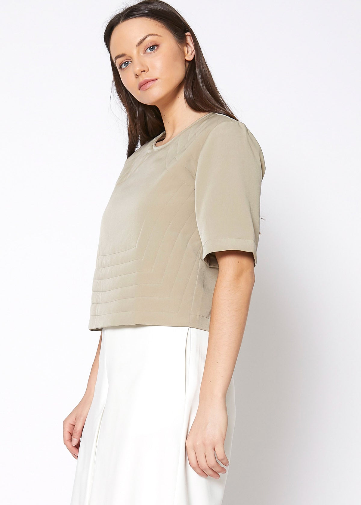 A stylish women's embossed short sleeve crop top in a minimal design, showcasing its unique texture and comfortable fit.