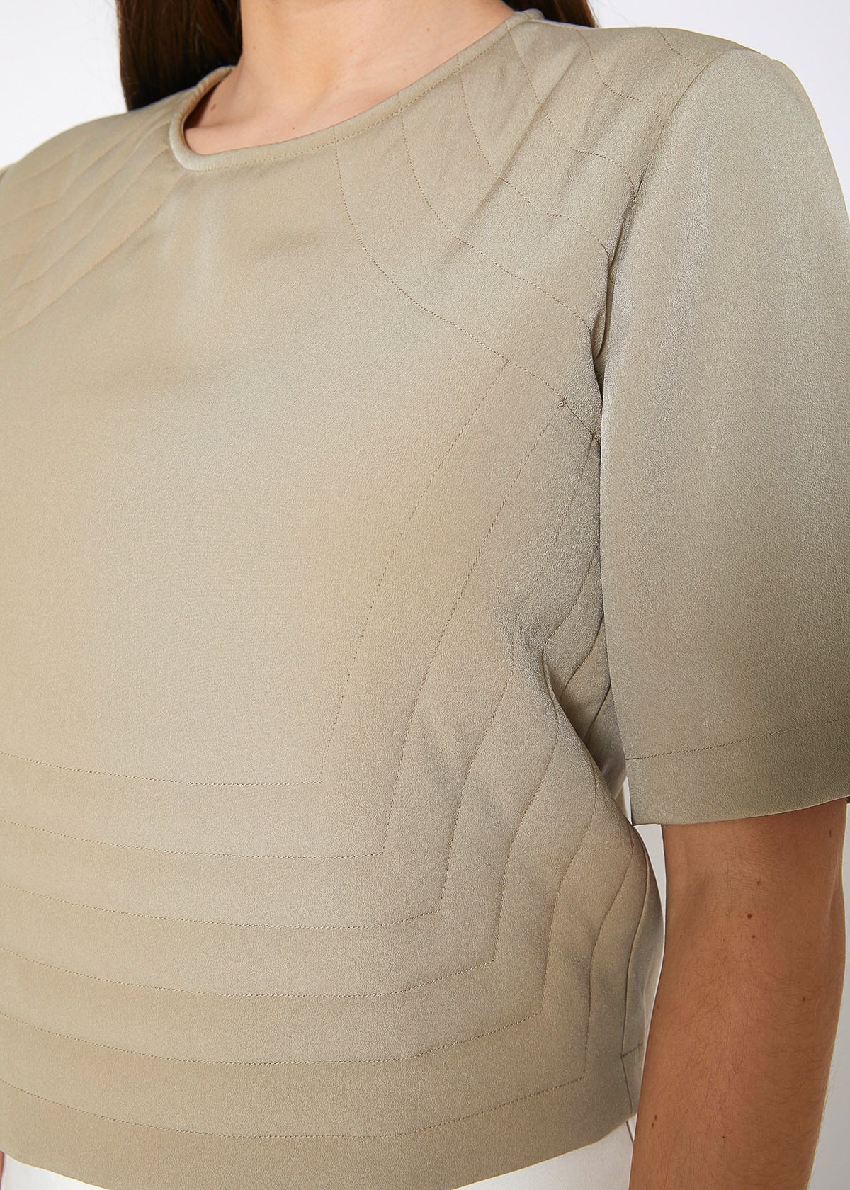 A stylish women's embossed short sleeve crop top in a minimal design, showcasing its unique texture and comfortable fit.