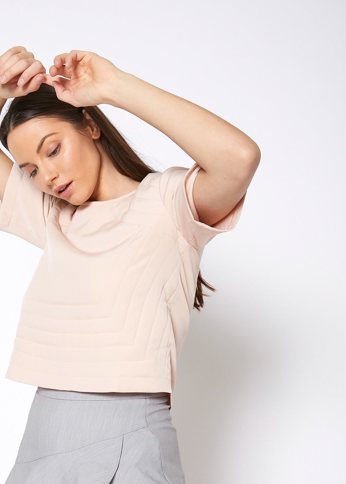 A stylish women's embossed short sleeve crop top in a minimal design, showcasing its unique texture and comfortable fit.