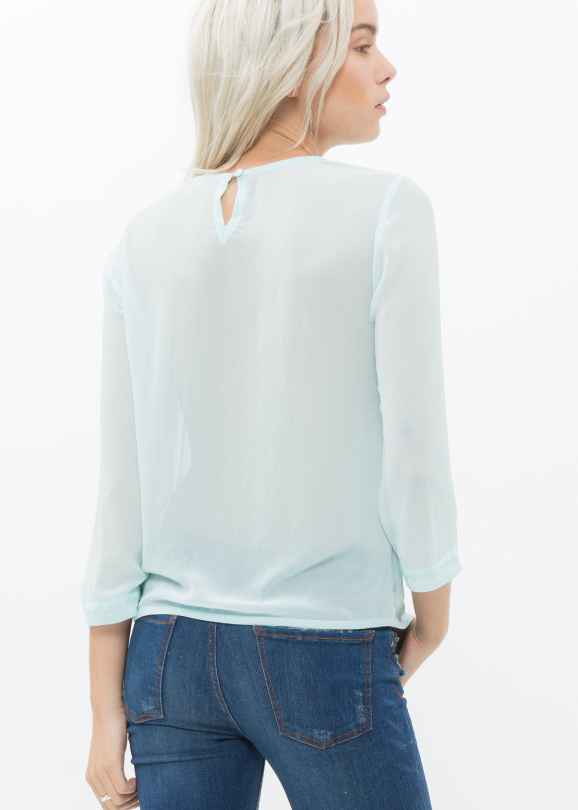 Women's embossed top in pepper mint with front embossing detail and button-back closure, made from 100% polyester.