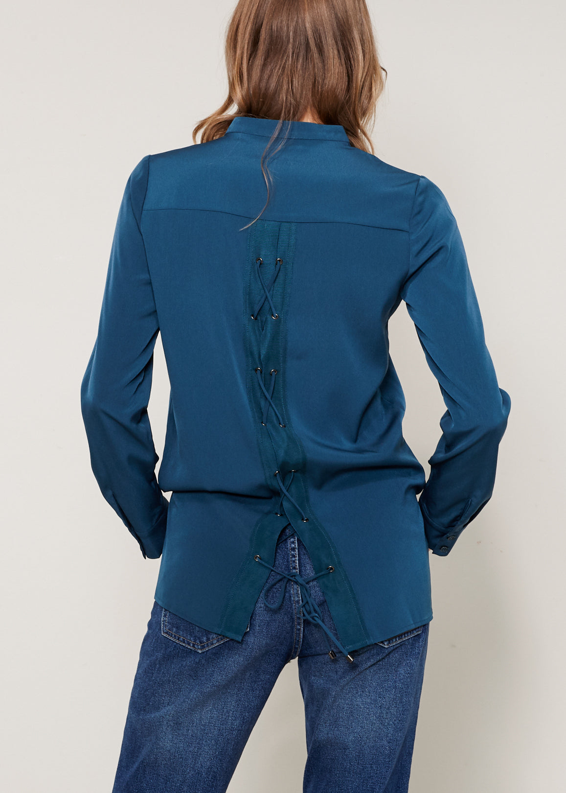 Women's Lace Back Blouse featuring a round split neck and tied lace back accent, showcasing a stylish hi-lo hem design.