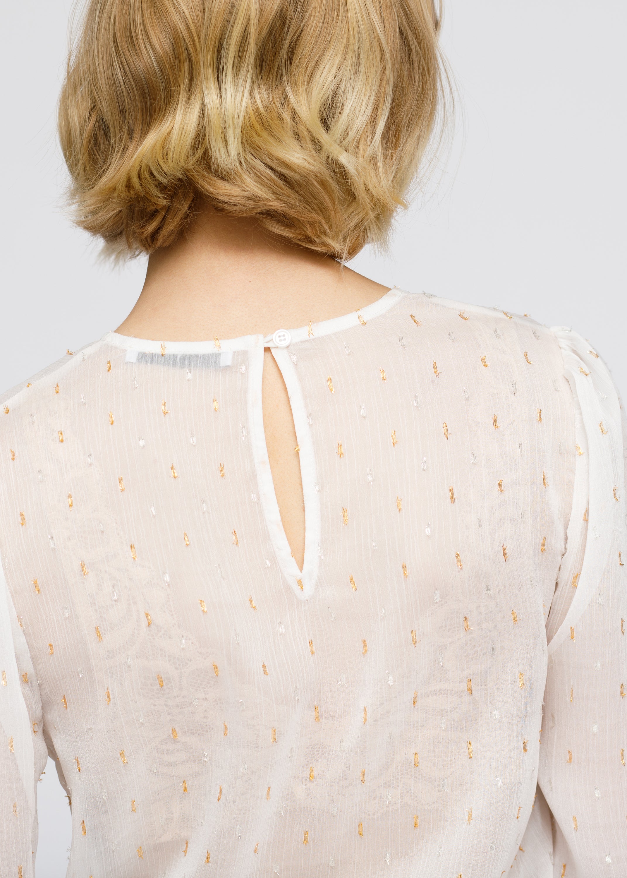 Women's white blouse featuring delicate lace inset and ruffle details, perfect for stylish occasions.