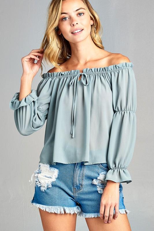 Woman in off-shoulder blouse, shorts.