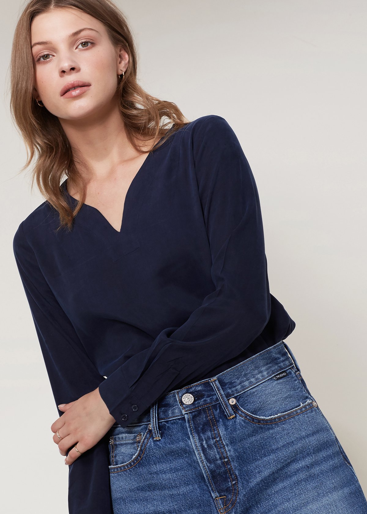 Women's Round Split Neck Hi-Lo Top featuring a stylish hi-lo hem and long sleeves with double button cuffs.