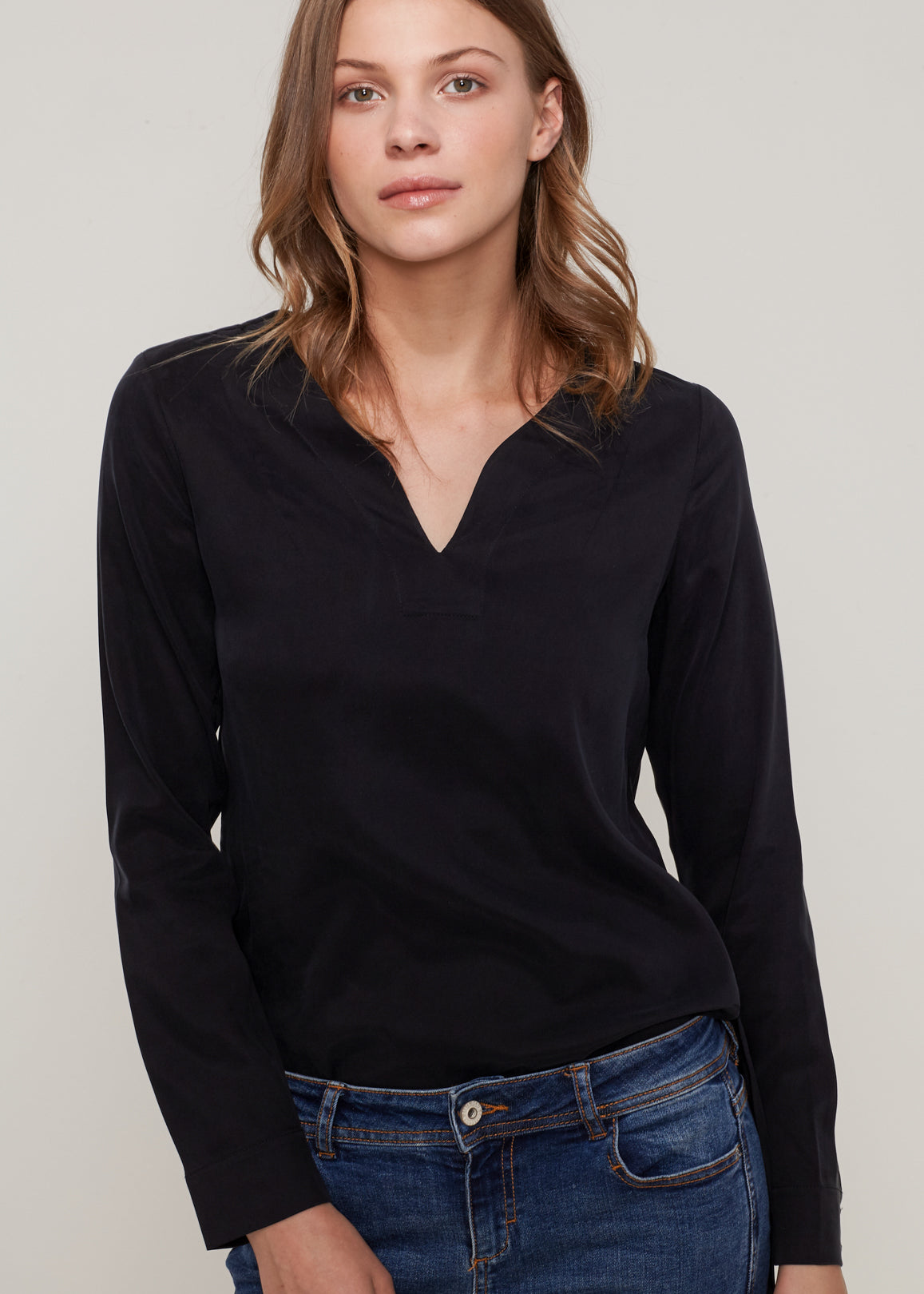 Women's Round Split Neck Hi-Lo Top featuring a stylish hi-lo hem and long sleeves with double button cuffs.