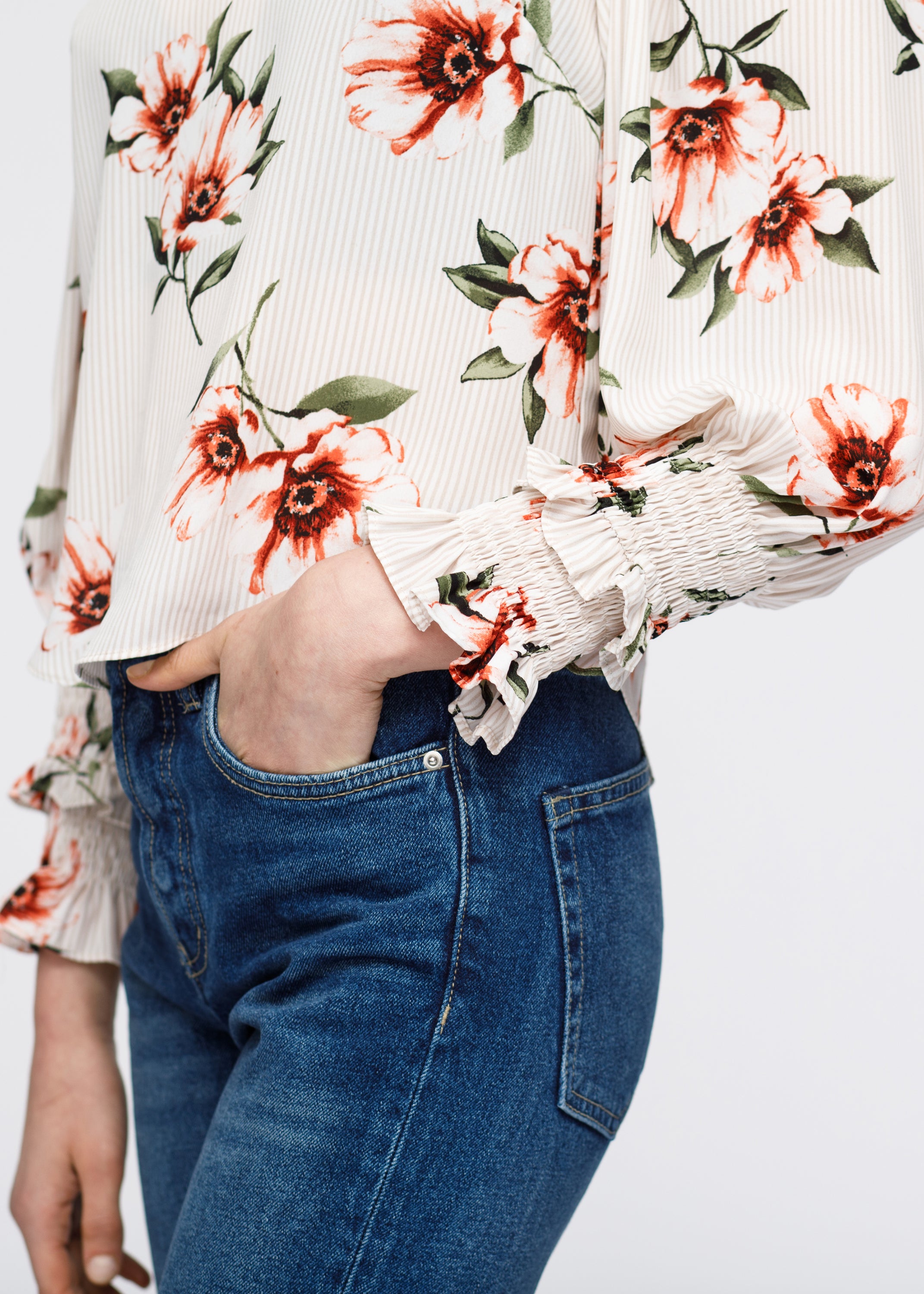 Women's taupe blouse featuring rust floral pinstripe print, smocked sleeves with ruffles, and mock neck design.