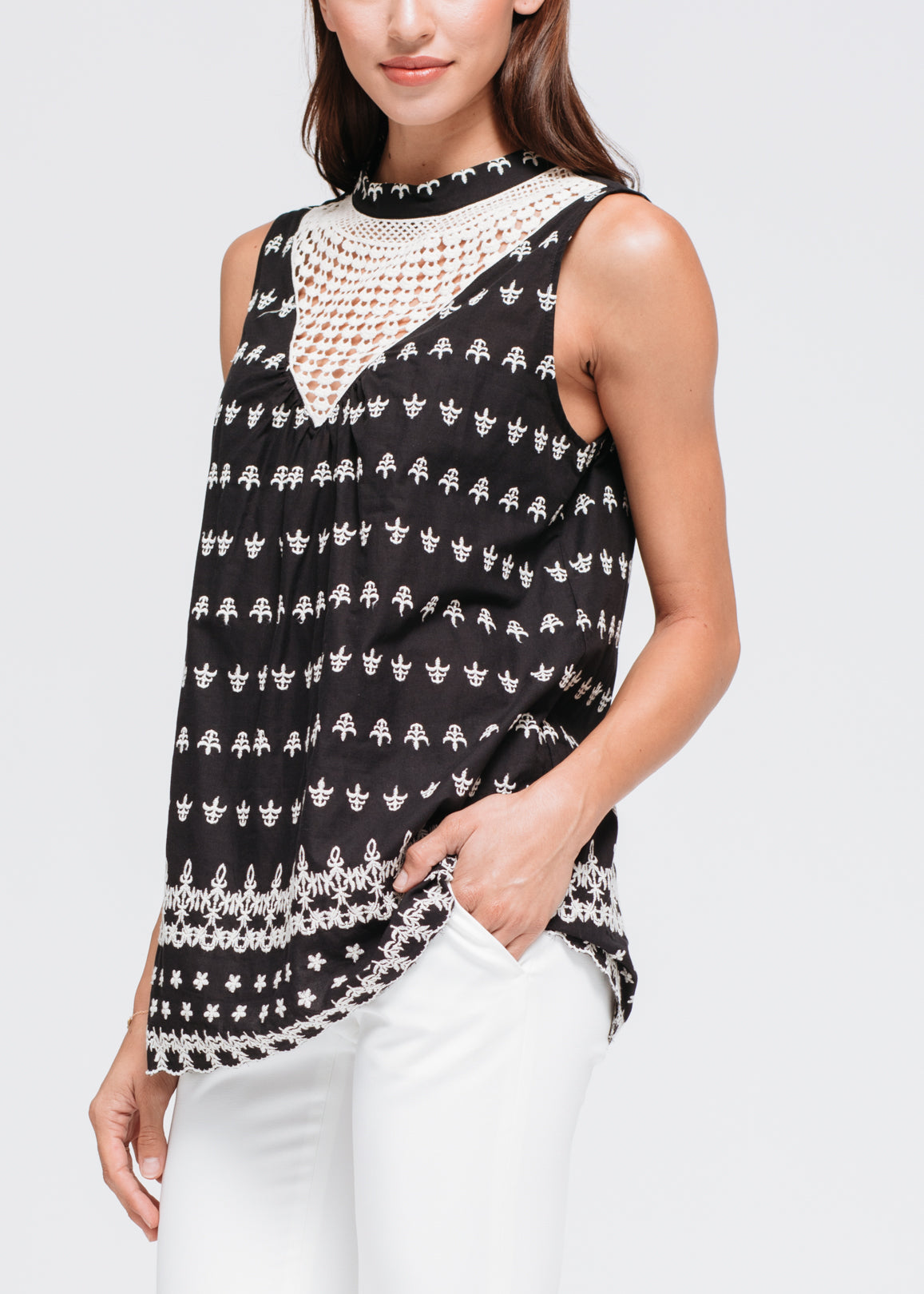 A stylish Women's Sleeveless Crochet Trim Top featuring intricate crochet detailing, a buttoned keyhole back, and made from soft 100% cotton fabric.