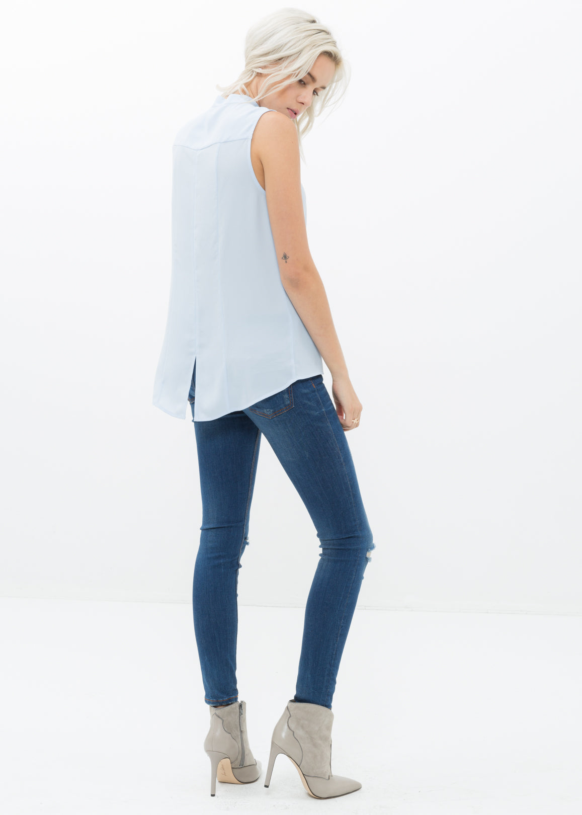 Women's stand collar sleeveless blouse in cloud blue with hidden-button fly closure and hi-lo slit hem.