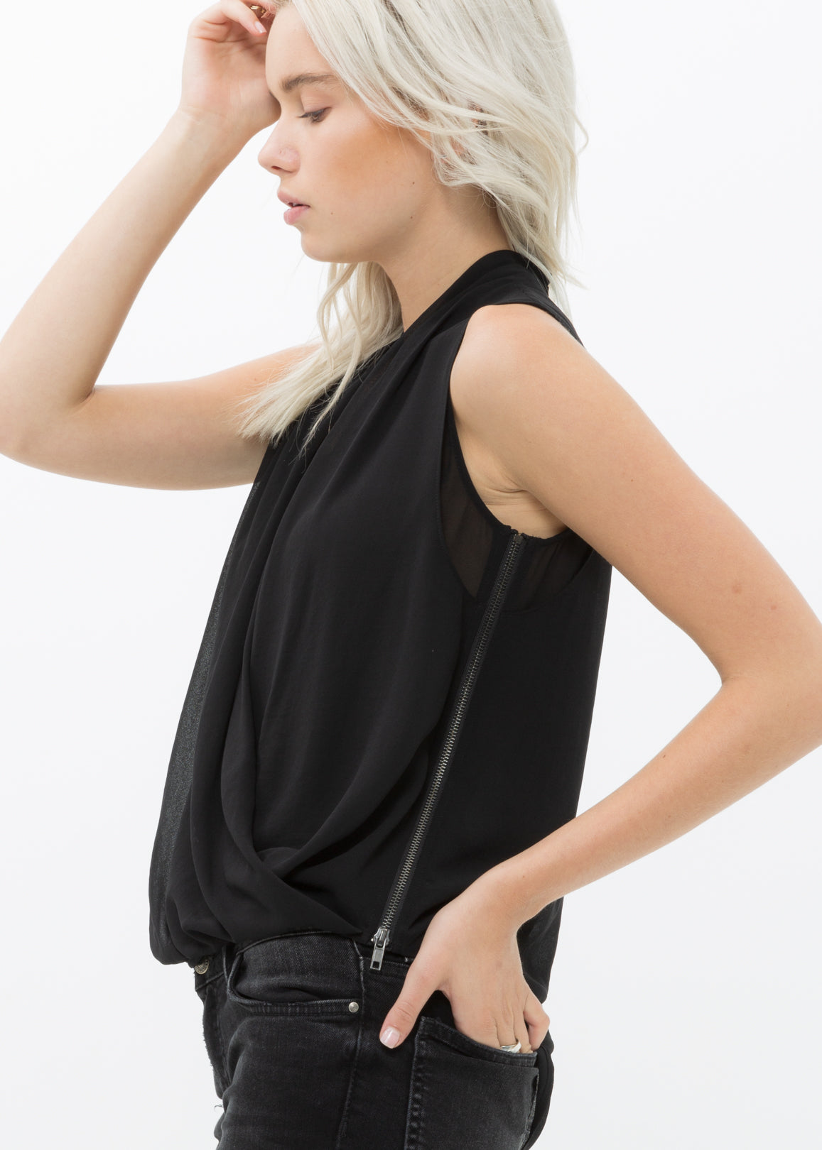 Women's black sleeveless surplice blouse with button back closure and side zip, showcasing a stylish and elegant design.