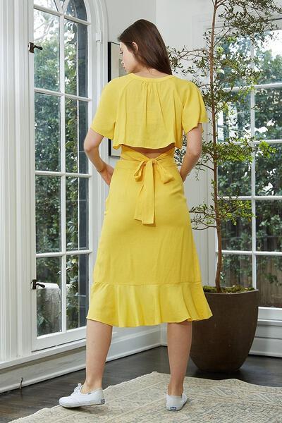 Women's yellow cropped blouse with tie waist and cape sleeves, showcasing a stylish V neckline.