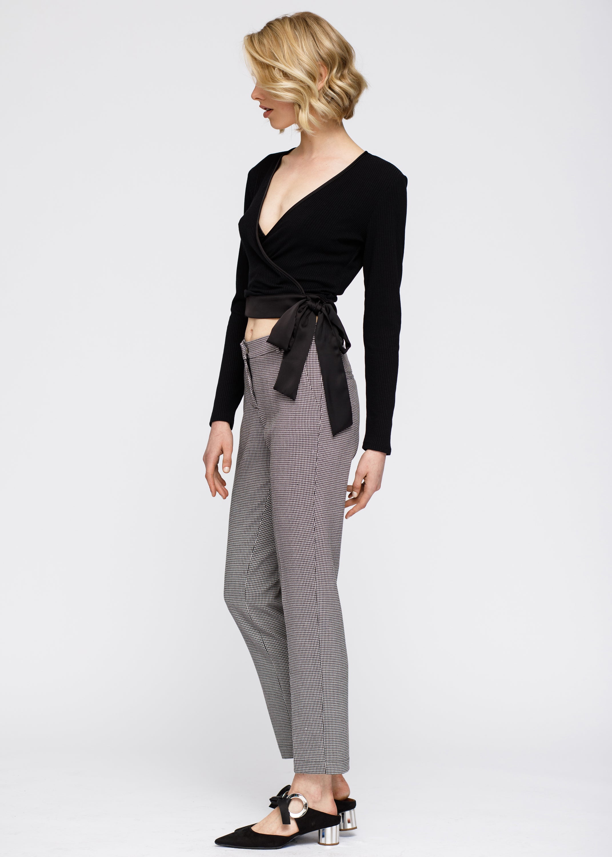 Women's black ribbed crop knit top with wrap front and satin ties, showcasing a stylish and modern design.