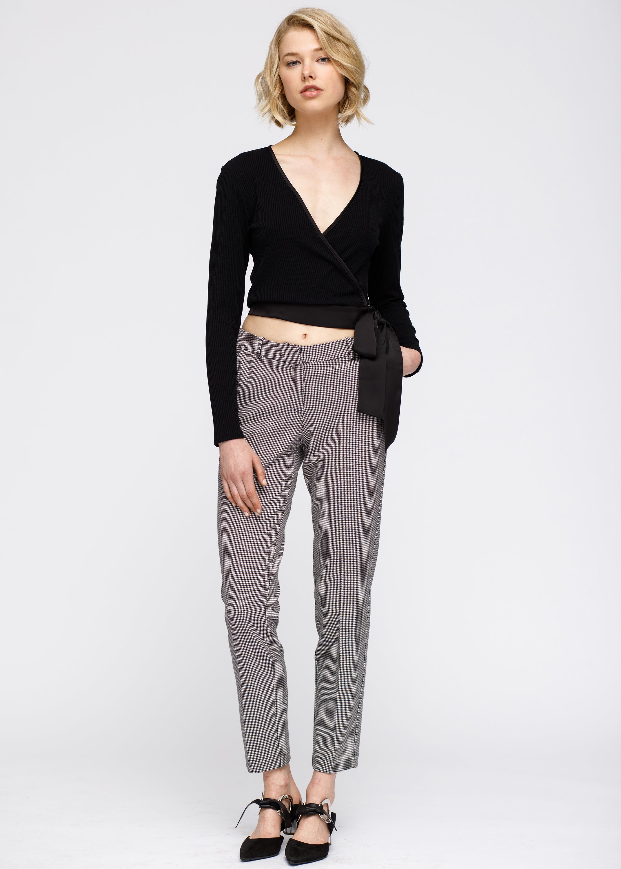 Women's black ribbed crop knit top with wrap front and satin ties, showcasing a stylish and modern design.