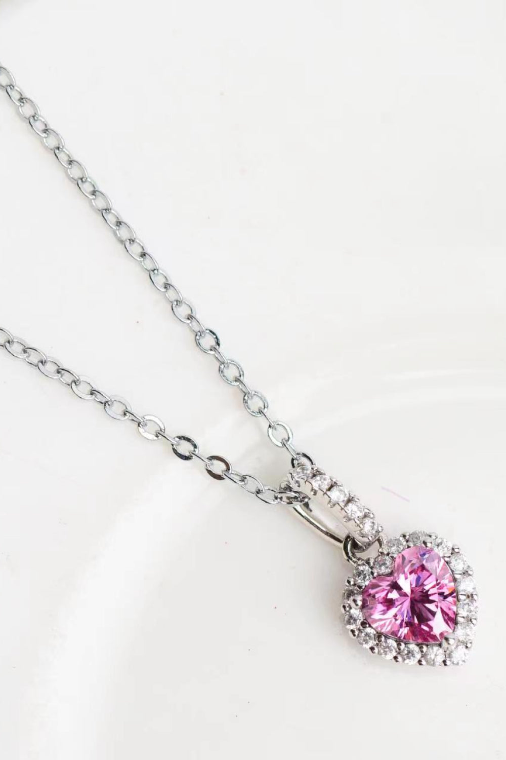 1 Carat Moissanite Heart Pendant Necklace in polished 925 sterling silver with platinum plating, displayed in a flat lay style.