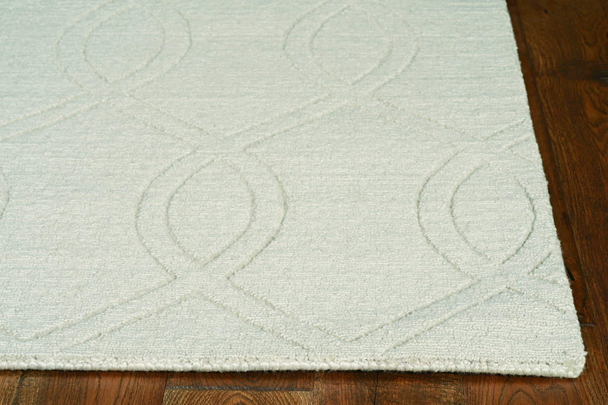 17" x 90" ivory polyester rug with embossed patterns, showcasing elegant tonal colors and a soft texture.