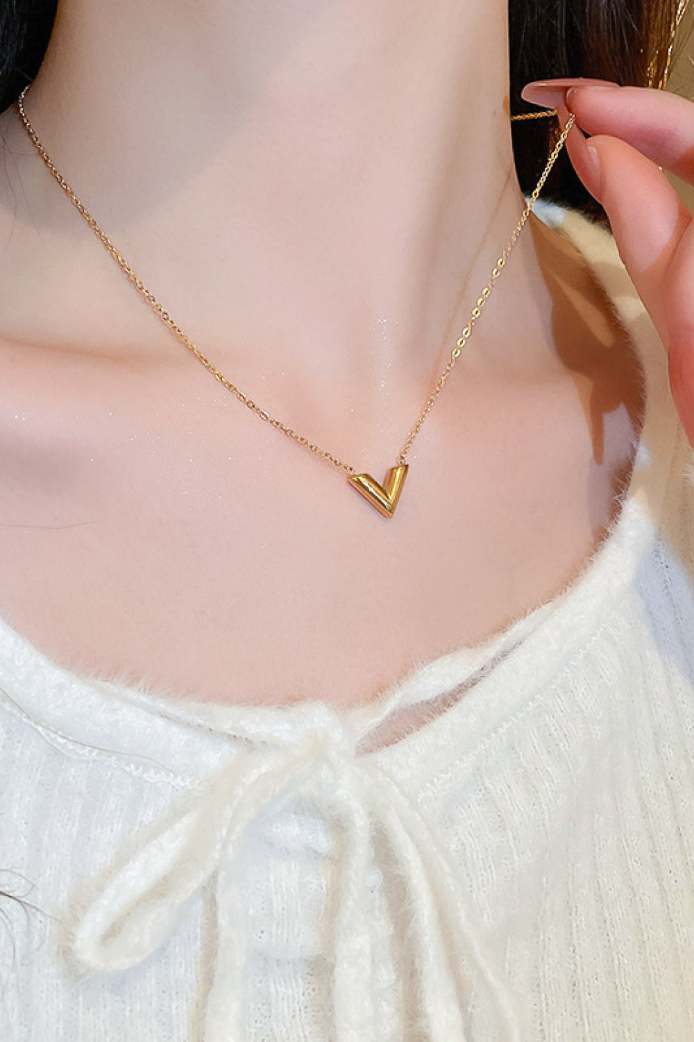 A delicate 18K gold plated V pendant necklace on a white background, showcasing its minimalist design and polished finish.