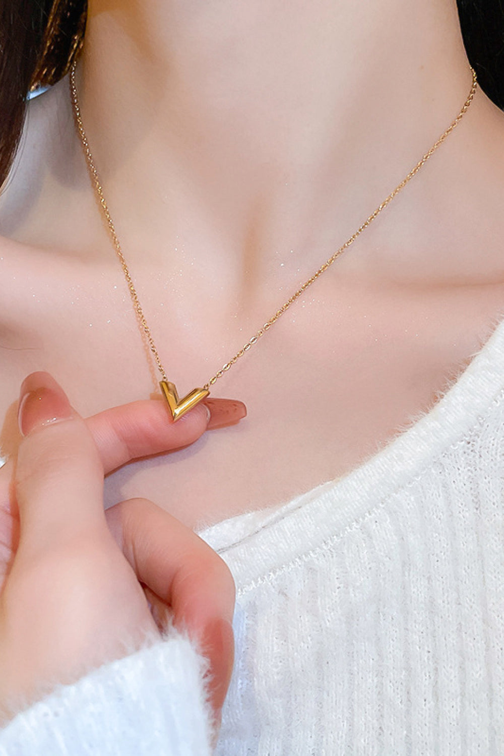 A delicate 18K gold plated V pendant necklace on a white background, showcasing its minimalist design and polished finish.